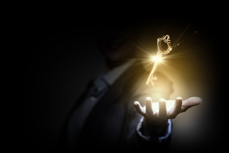 30993203 - close up image of business person holding shining key